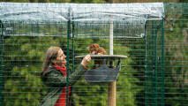 Woman enjoying time with her cat in a secure and weather protected catio