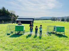 A family with their two chicken coops, in a green Missouri field
