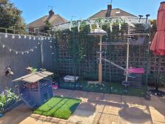 Some cats enjoying the sun from their outdoor cat tree, inside a catio