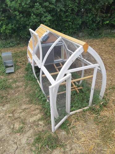 An automatic door opening on a wooden chicken coop.
