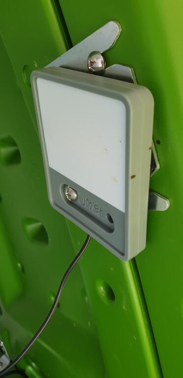 An omlet coop light attached the top of an Eglu Cube chicken coop.
