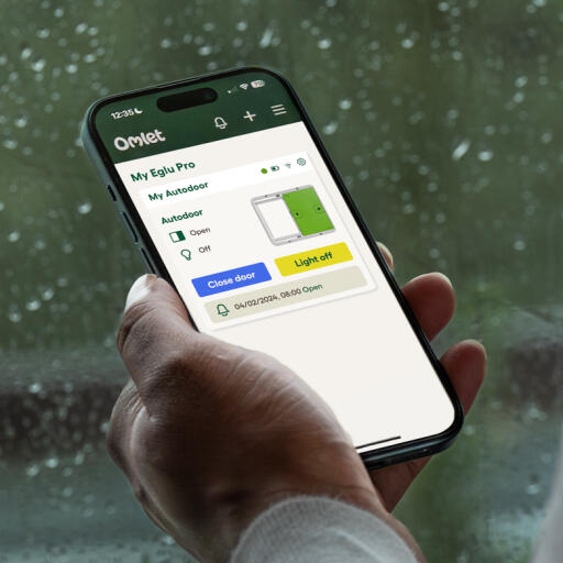 hand holding a phone with the omlet smart autodoor app open