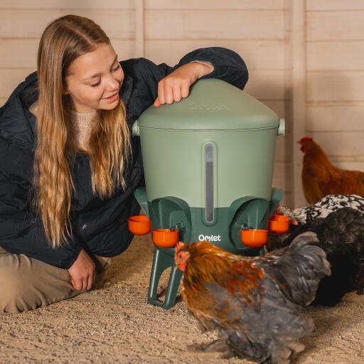 girl resting on tip proof insulated chicken waterer