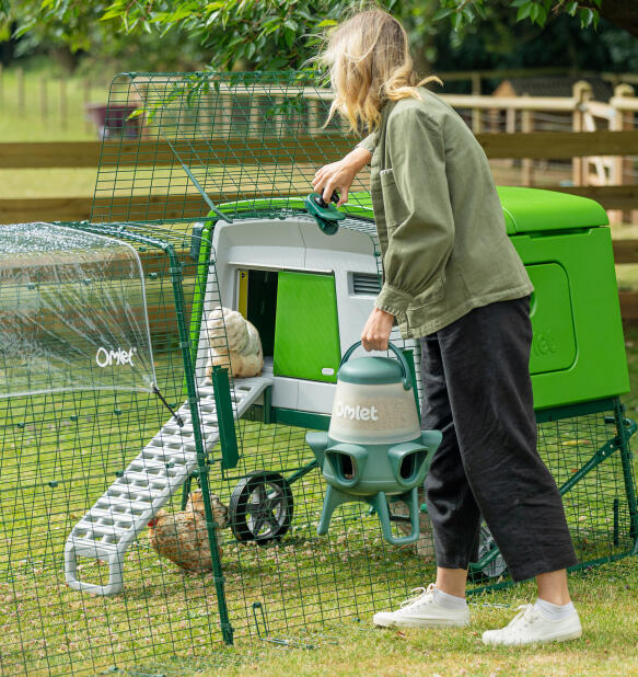 woman accessing her coop run using the easy access run door