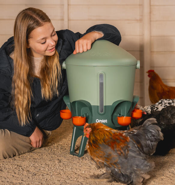 girl leaning on an anti-topple study chicken waterer