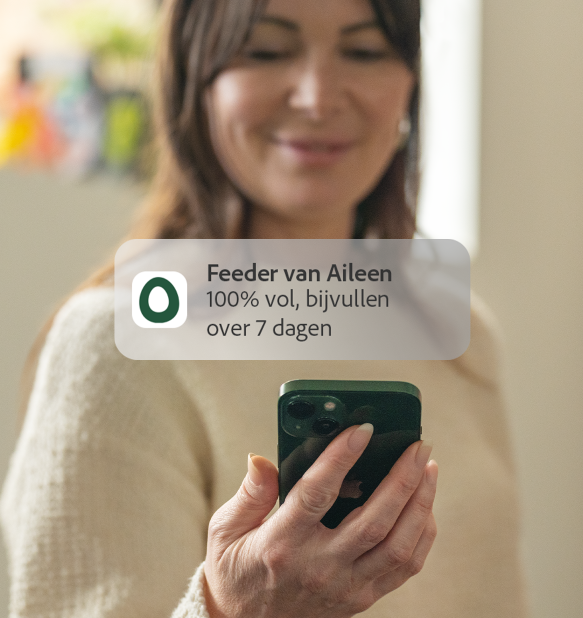 Vrouw ontvangt melding op Omlet app feed level op haar telefoon
