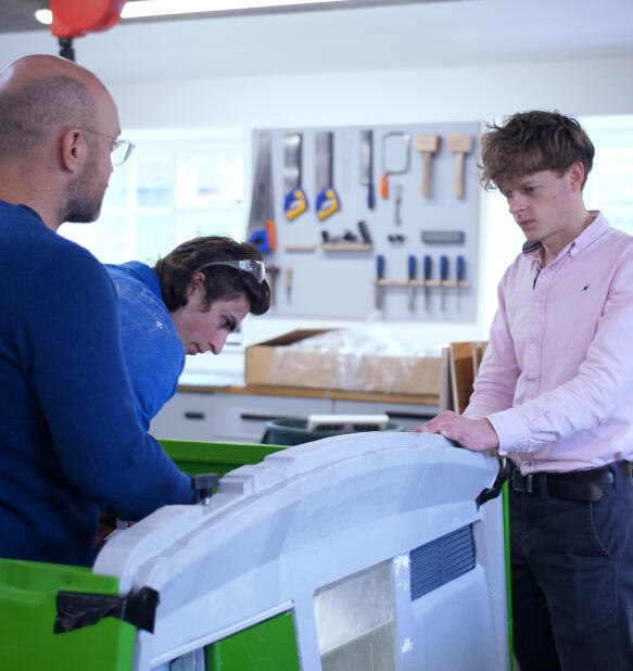 Omlet engineers in the workshop with chicken coop prototype
