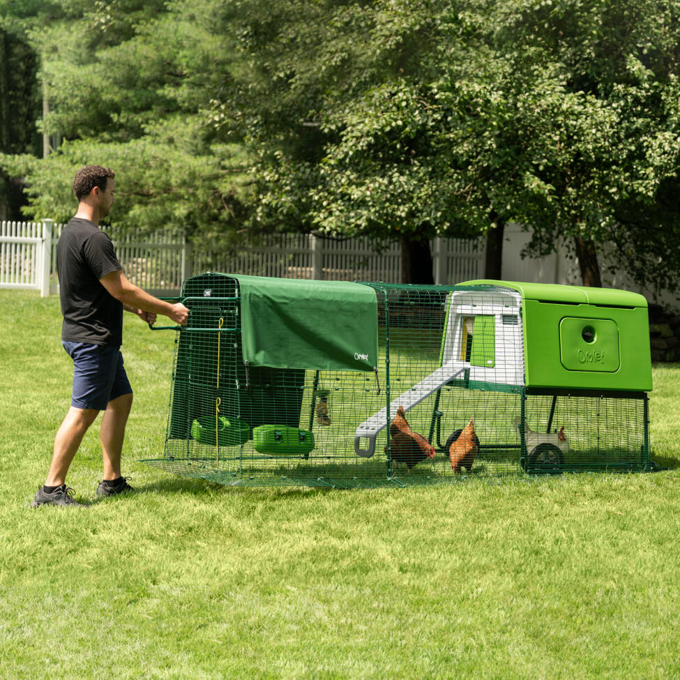 Man moving the Eglu Cube portable plastic chicken coop